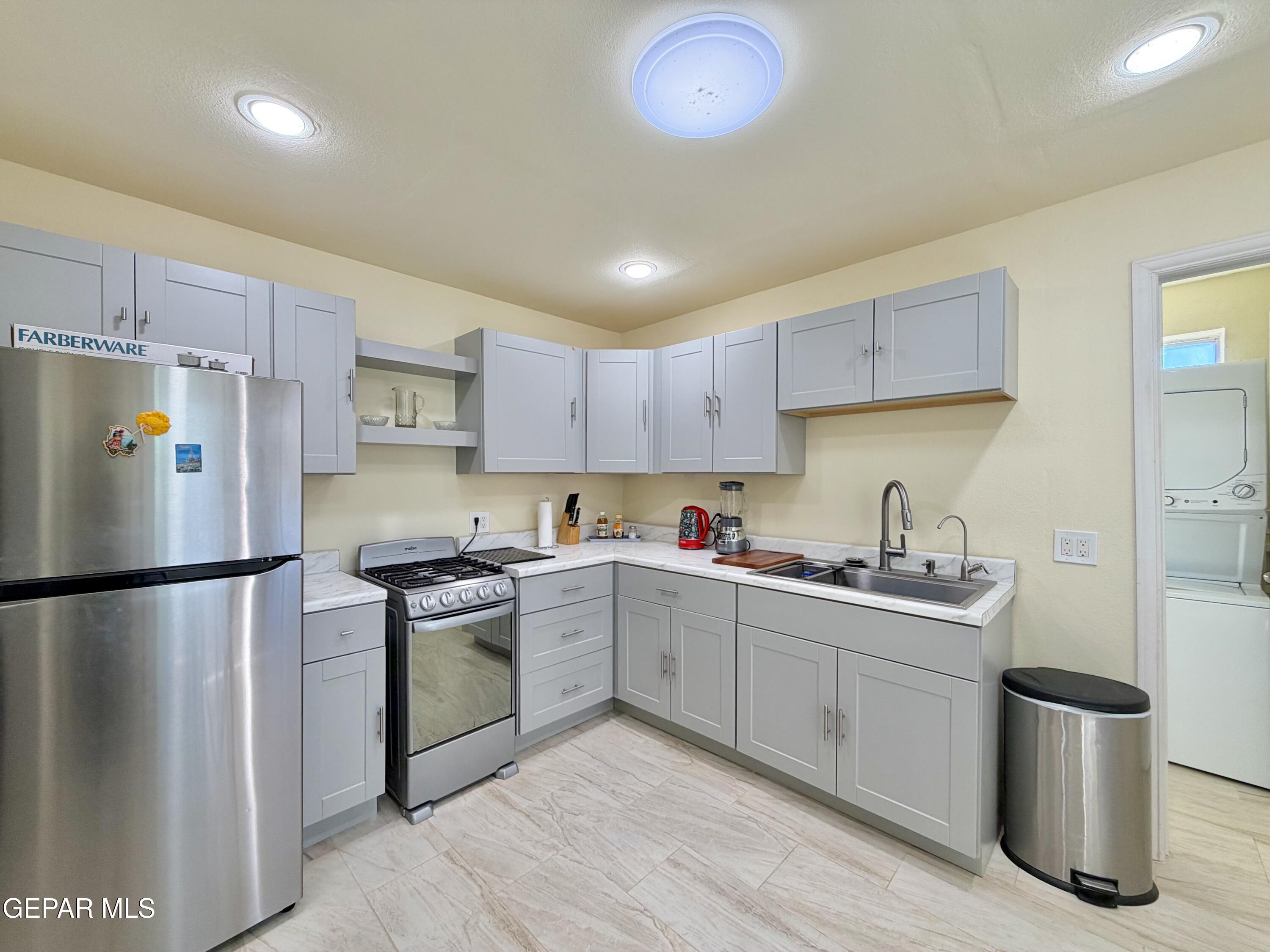 2452 West Ohara Road Anthony, NM 88021 - Photo 38 of 56 a kitchen with a sink a refrigerator and white cabinets