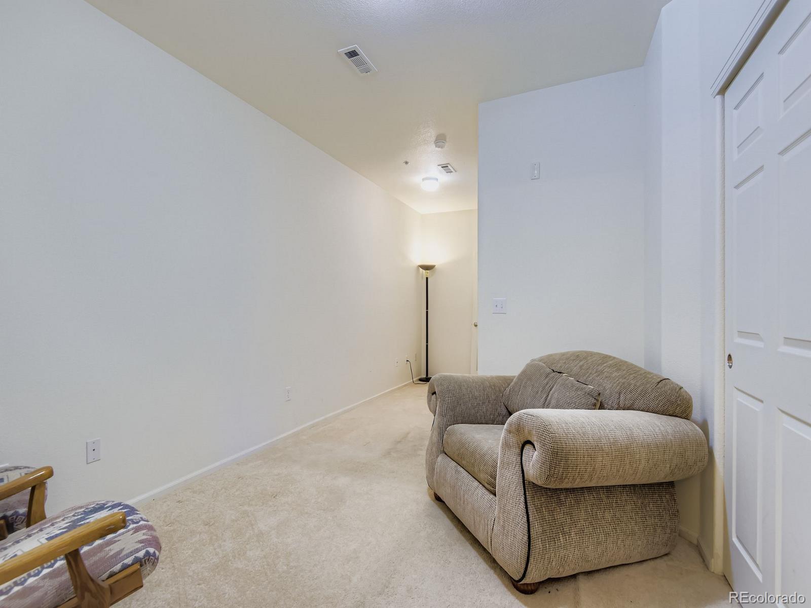 5255 Memphis Street, Unit 307 Denver, CO 80239 - Photo 18 of 29 a living room with furniture and a lamp