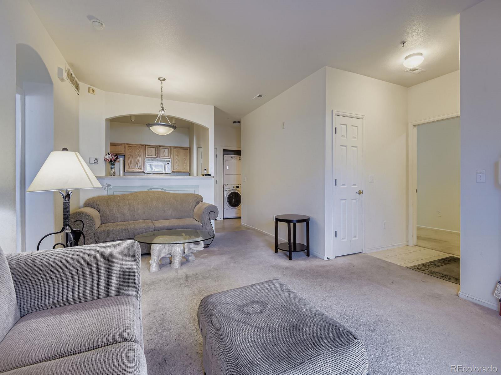 5255 Memphis Street, Unit 307 Denver, CO 80239 - Photo 19 of 29 a bedroom with furniture and a lamp