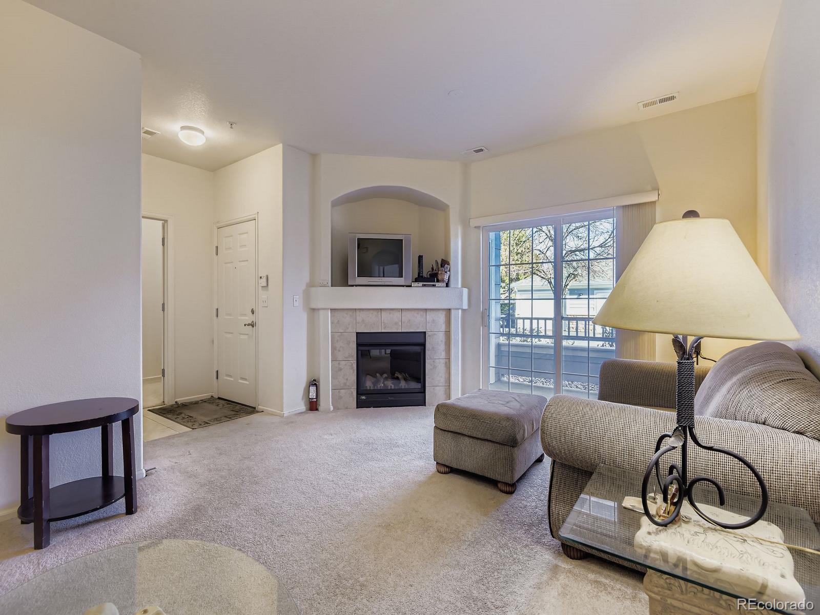 5255 Memphis Street, Unit 307 Denver, CO 80239 - Photo 2 of 29 a living room with furniture and a fireplace