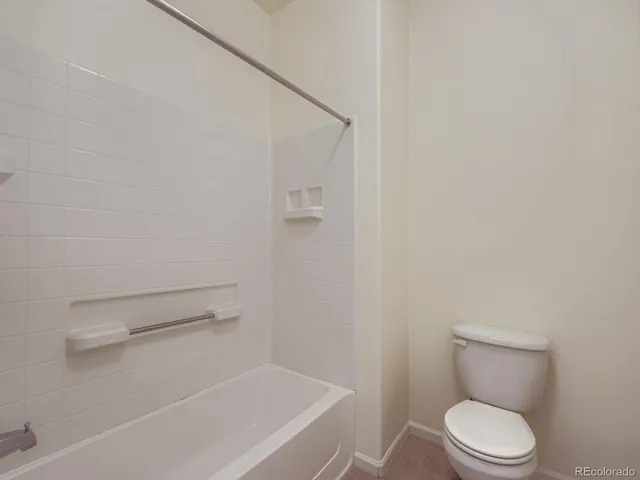 a white toilet sitting next to a shower