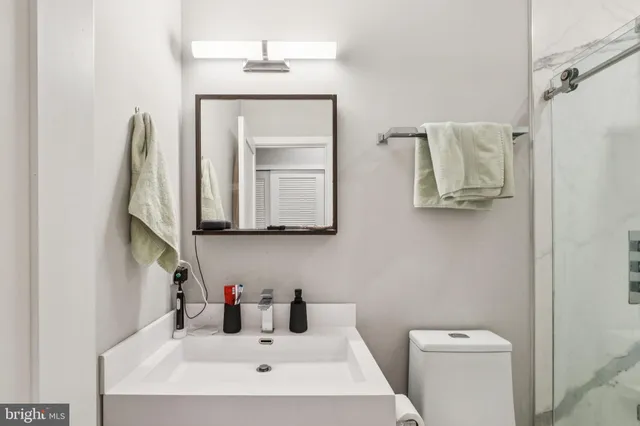 a bathroom with a toilet sink and mirror