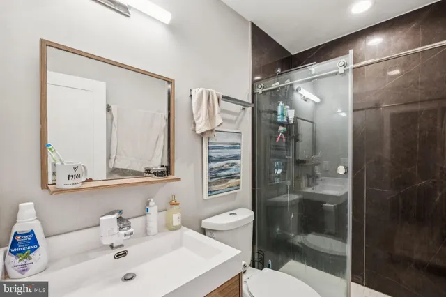 a bathroom with a sink a toilet and shower