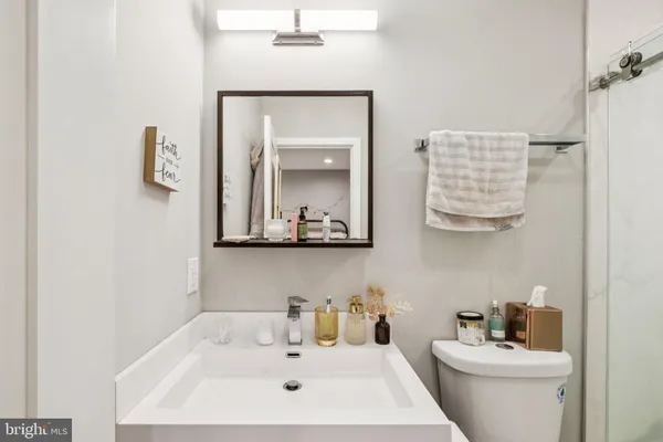 a bathroom with a sink a toilet and mirror
