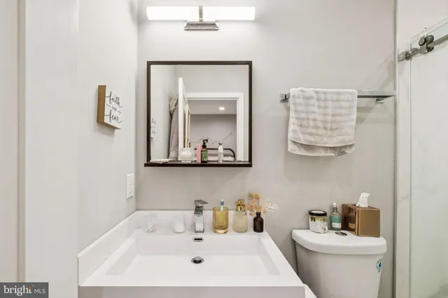 a bathroom with a sink a toilet and mirror