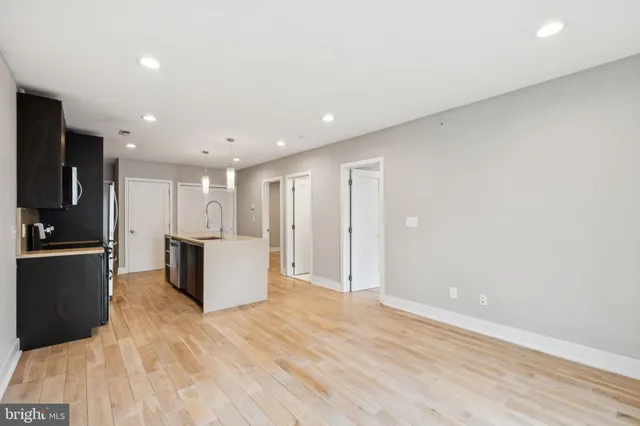 a view of kitchen with refrigerator and white cabinets
