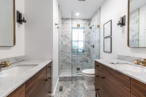 a bathroom with a granite countertop sink toilet and shower