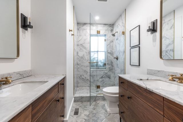 a bathroom with a granite countertop sink toilet and shower