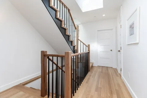 a view of a hallway with wooden floor and entryway