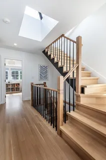 a view of a hallway with wooden floor and stairs