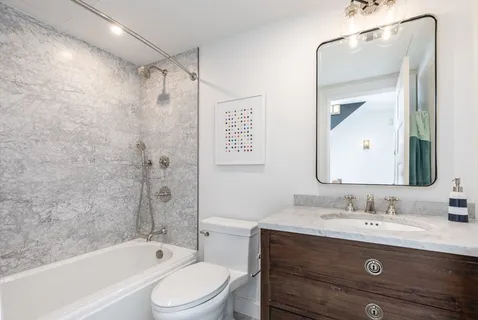 a bathroom with a granite countertop sink toilet and shower