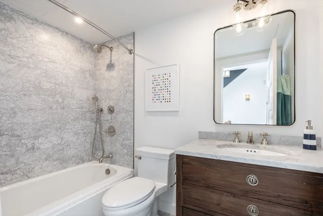 a bathroom with a granite countertop sink toilet and shower