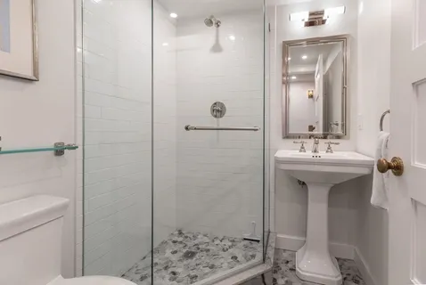 a bathroom with a sink a toilet and shower