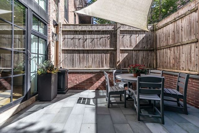 a view of a balcony with chairs potted plants with wooden floor and fence