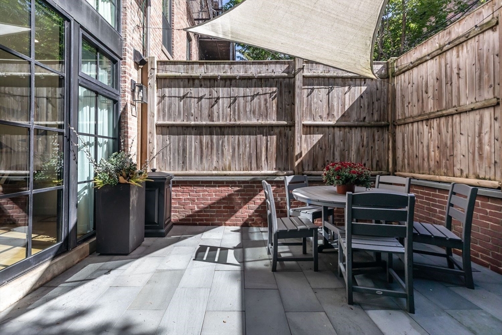 27 Lawrence Street Boston, MA 02116 - Photo 29 of 38 a view of a balcony with chairs potted plants with wooden floor and fence