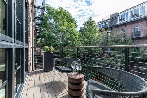 a picture of a roof deck with table and chairs and wooden floor
