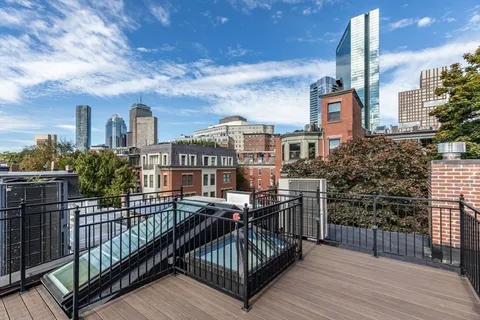 a view of a roof deck with chair and wooden floor