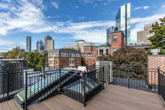 a view of a roof deck with chair and wooden floor