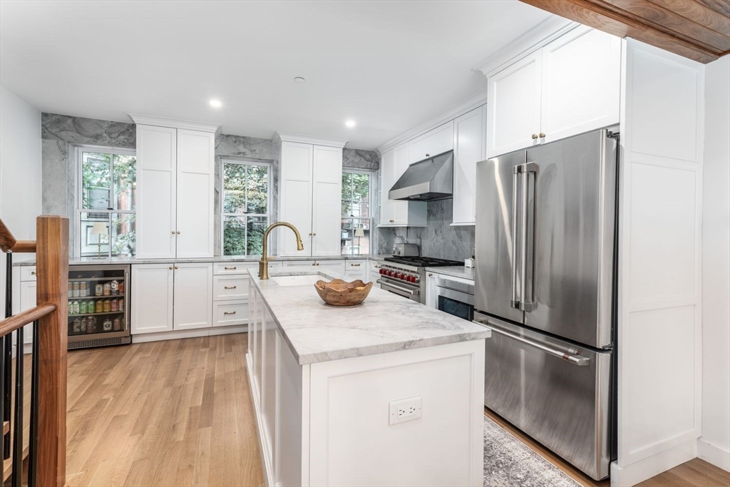 27 Lawrence Street Boston, MA 02116 - Photo 4 of 38 a kitchen with stainless steel appliances granite countertop a refrigerator a stove and a sink with wooden floor