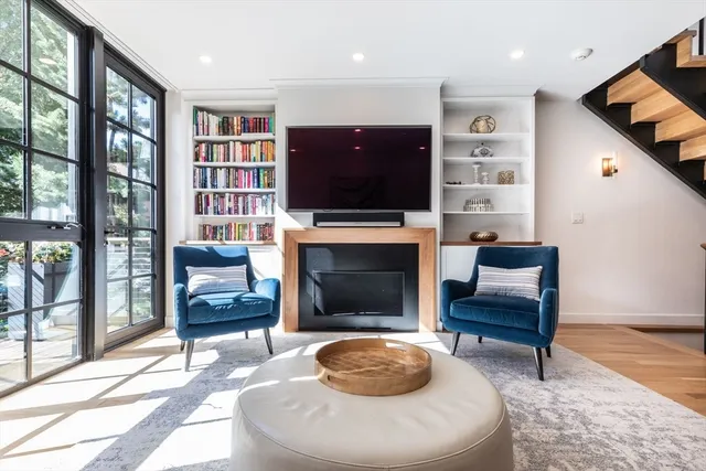 a living room with furniture a flat screen tv and a fireplace