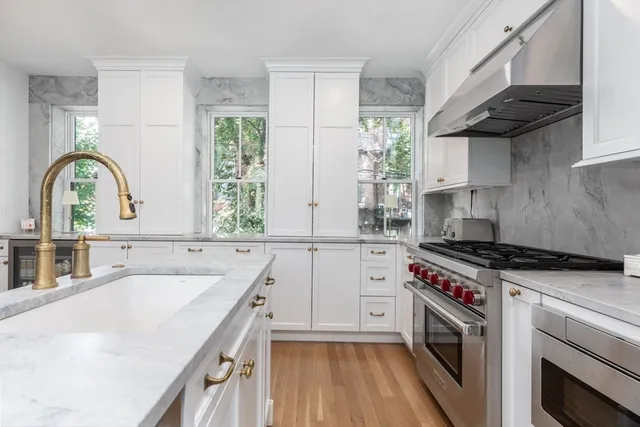 a kitchen with a sink stove top oven and cabinets