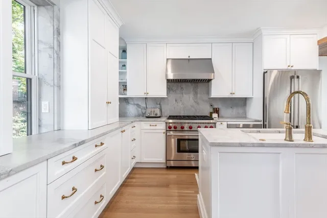 a kitchen with granite countertop a sink stove and refrigerator