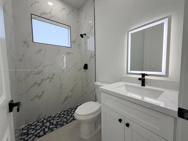 an empty room with closet and a ceiling fan