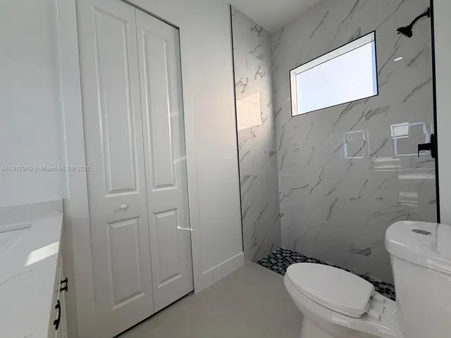 an empty room with wooden floor and a ceiling fan