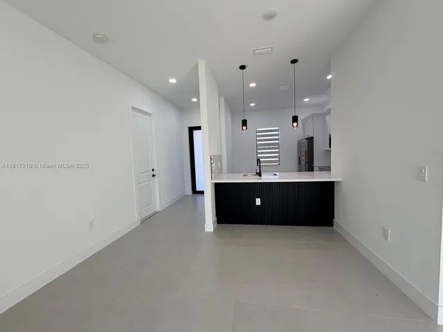 an empty room with ceiling fan and windows