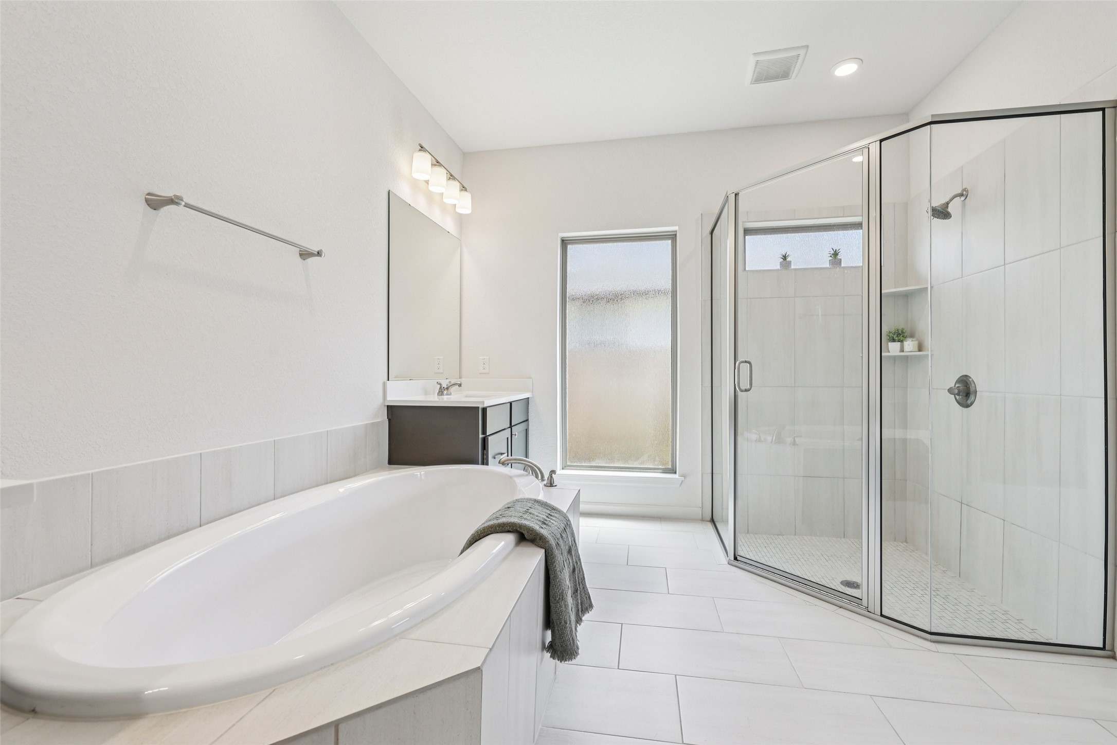 1140 Bryson Rdg Trail Leander, TX 78641 - Photo 17 of 39 Spacious bathroom featuring a soaking tub, a large glass-enclosed shower, and a vanity with a mirror