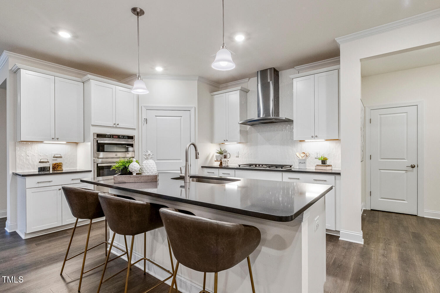 1116 Ciandra Barn Way Apex, NC 27523 - Photo 8 of 59 a kitchen with stainless steel appliances granite countertop a sink a stove a refrigerator and white cabinets with wooden floor