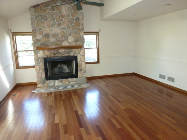 107 Country Court Bolingbrook, IL 60440 - Photo 8 of 13 an empty room with wooden floor fireplace and windows