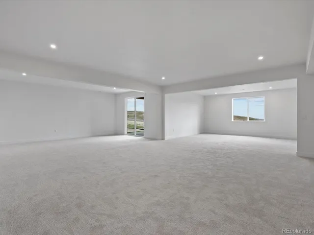 a view of a big room with windows and chandelier fan