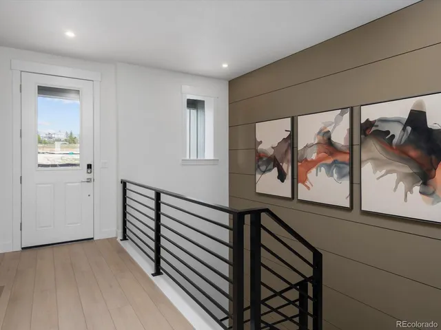 a view of a hallway with wooden floor and stairs