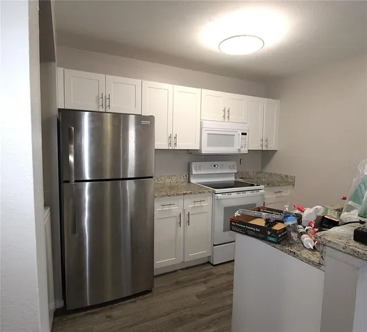 a kitchen with a refrigerator sink and cabinets