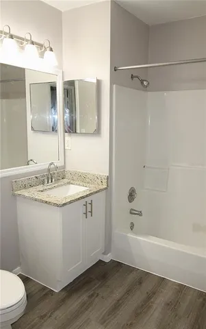 a bathroom with a granite countertop sink toilet and shower