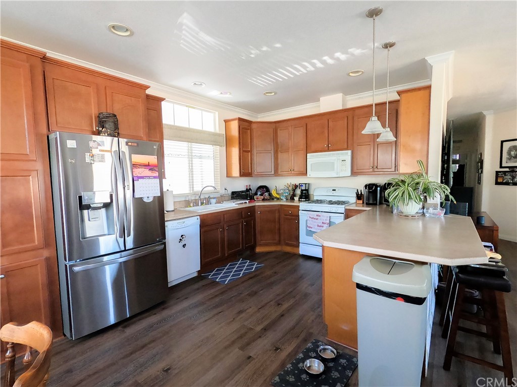 1051 Site Drive, Unit 286 Brea, CA 92821 - Photo 5 of 25 a kitchen with stainless steel appliances a refrigerator a stove a sink dishwasher a oven with white cabinets and wooden floor