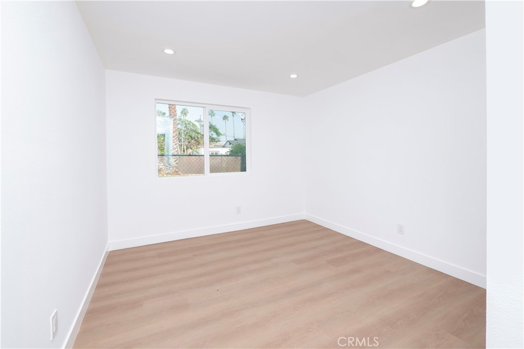 5741 South St Andrews Place, Unit 1/2 Los Angeles, CA 90062 - Photo 11 of 28 an empty room with wooden floor and windows