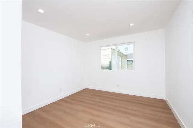 an empty room with wooden floor and window