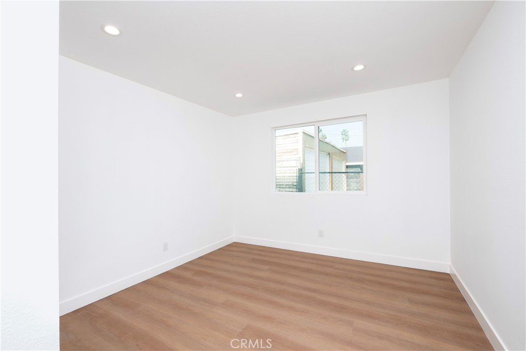 5741 South St Andrews Place, Unit 1/2 Los Angeles, CA 90062 - Photo 13 of 28 an empty room with wooden floor and window