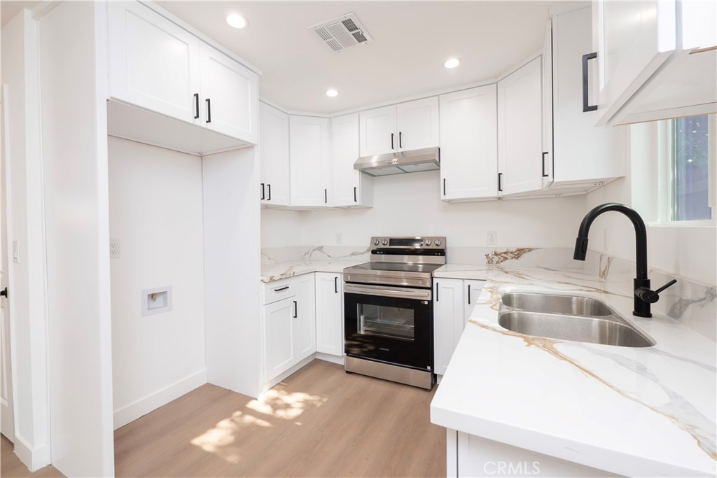 5741 South St Andrews Place, Unit 1/2 Los Angeles, CA 90062 - Photo 17 of 28 a kitchen with granite countertop a sink cabinets and stainless steel appliances