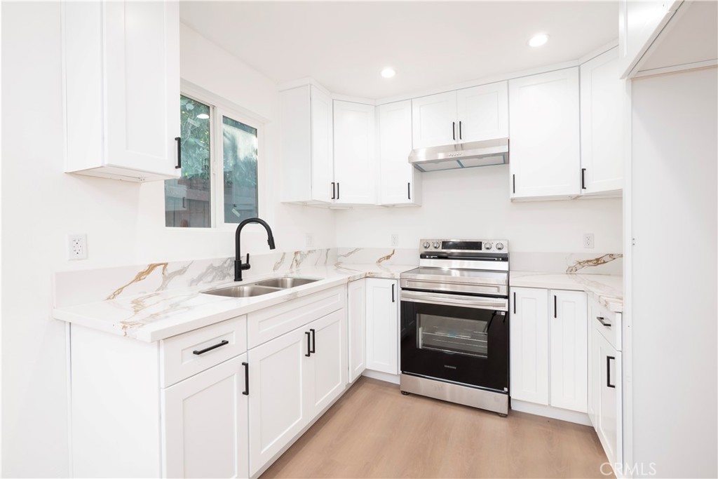 5741 South St Andrews Place, Unit 1/2 Los Angeles, CA 90062 - Photo 2 of 28 a kitchen with stainless steel appliances granite countertop a stove sink and cabinets