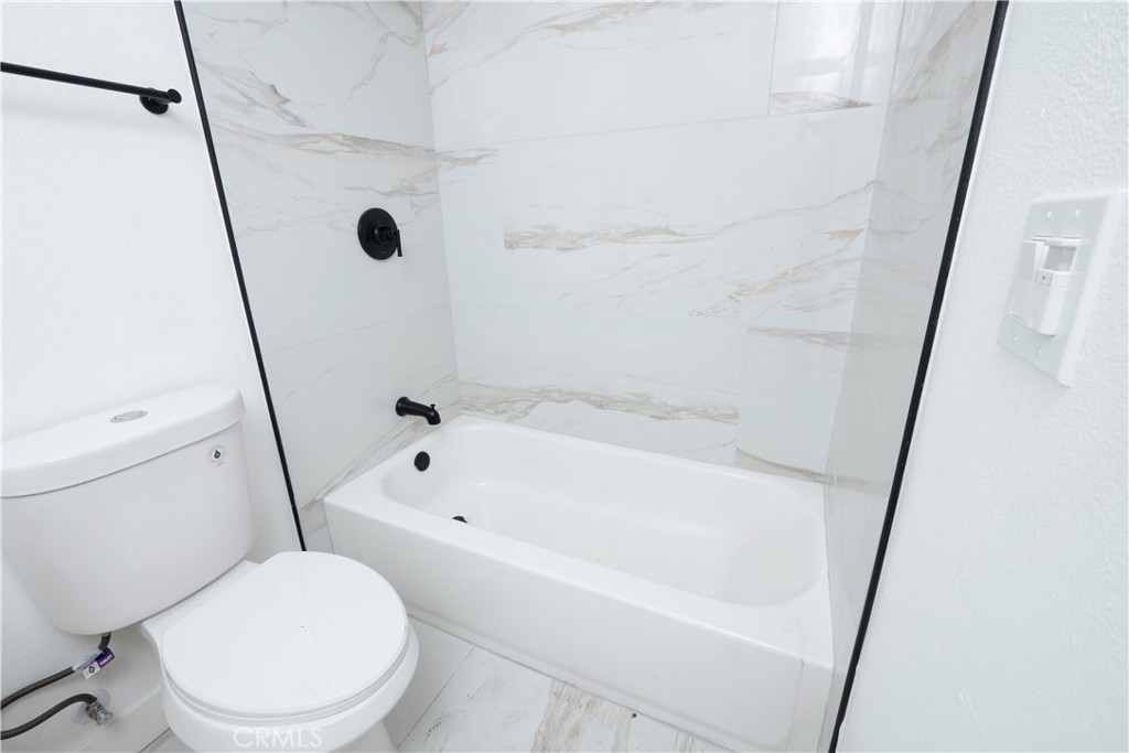 5741 South St Andrews Place, Unit 1/2 Los Angeles, CA 90062 - Photo 22 of 28 a white toilet sitting next to a tub