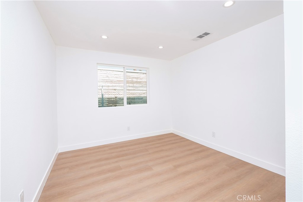 5741 South St Andrews Place, Unit 1/2 Los Angeles, CA 90062 - Photo 23 of 28 an empty room with wooden floor and windows
