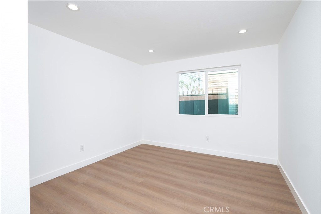 5741 South St Andrews Place, Unit 1/2 Los Angeles, CA 90062 - Photo 25 of 28 a view of empty room with wooden floor and fan
