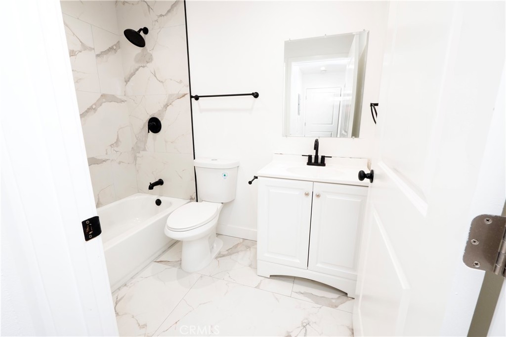 5741 South St Andrews Place, Unit 1/2 Los Angeles, CA 90062 - Photo 9 of 28 a bathroom with a sink a toilet and shower