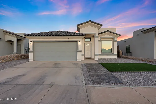 a front view of a house with a yard and garage