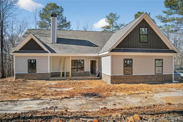 a front view of a house with a yard covered in snow