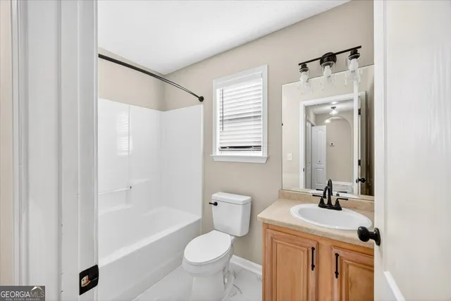a bathroom with a sink toilet a mirror and shower