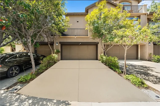 a view of a white house next to a yard with big trees